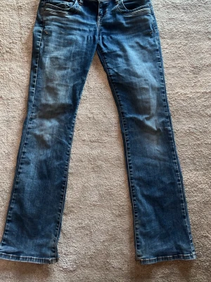 Blå bootcut jeans - Säljer ett par superfina blå ltb bootcut jeans i modellen valerie som ser lite urtvättade ut. Använt mycket och har fått ett hål som inte syns men därav priset. Jag är 166 cm