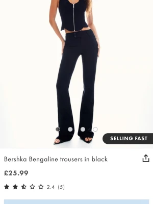 Svarta Bengaline kostymbyxor Bershka - De virala kostymbyxor från Bershka med prislappen kvar. Har stretchigt bengalin-tyg. Byxorna har utsvängda ben, hög midja och knapp- samt dragkedjestängning framtill. Perfekta för en trendig och stilren look.