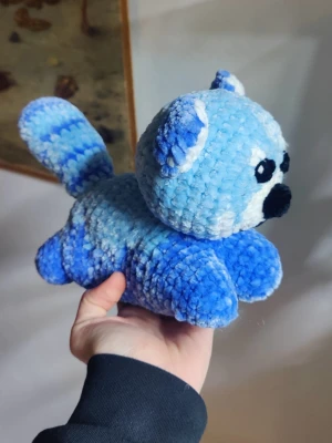 Blått virkat gosedjur panda  - Supergulligt blått gosedjur i form av en panda, virkat i mjukt och fluffigt garn. Har stora svarta ögon, vit nos och randig svans. Perfekt som present eller dekoration i rummet.