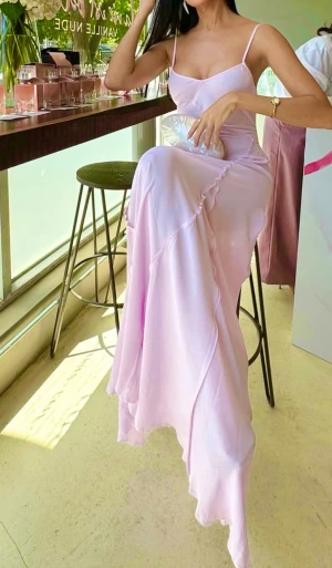 Ljuslila långklänning med volang Victoria Beckham xMango S - Ny Ljuslila långklänning med volang Victoria Beckham xMango, storlek S .  100% viskos. Elegant långklänning i ljuslila med mjukt fall och subtil volangdetalj framtill. Klänningen har en figurnära passform upptill och är ärmlös med smala axelband. Perfekt för dig som vill ha en romantisk och stilren look.