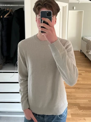 Beige stickad tröja från Samsoe Samsoe - Säljer en stilren beige stickad tröja från Samsoe Samsoe. Tröjan har rund halsringning, långa ärmar och ribbade muddar vid ärmslut och nederkant. Perfekt basplagg i garderoben och enkel att matcha till jeans eller byxor. Model är 190 cm och 80 kg men den är lite liten. 100 % Ull