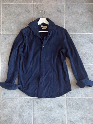 Skjorta  - Snygg mörkblå skjorta från Lacrosse Premium Line i slim fit-modell. Skjortan har diskret mönster, klassisk krage och långa ärmar. Perfekt för dig som gillar stilrena plagg med en twist. OBS!! Använd Instabox när ni beställer, smidigare för mig att kunna leverera snabbare😊