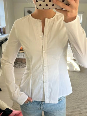 Vit figursydd skjorta - Vit skjorta med indragen midja och raka ärmar. Aldrig använd!