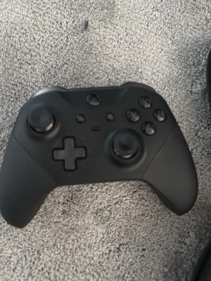 Svart Xbox Elite handkontroll - Säljer en svart Xbox Elite handkontroll med matt finish och ergonomisk design. Handkontrollen har utbytbara styrspakar och D-pad, samt extra knappar på baksidan för mer avancerad gaming. OBS: en vänsterknapp saknas  Kommer med tillbehör och förvaringsväska.