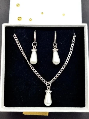 Smyckesetet  - Smyckesetet påminner om Maria Nilsdotter. Material-rostfritt stål. Örhängen längd-3,7cm, halsband längd-40cm. 