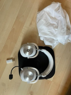 Logitech G Pro X Gaming Headset - Säljer ett Logitech G Pro X gaming headset i vit och silver med avtagbar mikrofon och USB-adapter. Hörlurarna har stora, rundade kåpor i metall och mjukt vadderat huvudband för extra komfort. Perfekt för gaming och voice chat.