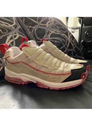 Beige och röda sneakers från Royal Elastic - Unika sneakers  i beige  med röda detaljer och svart tåparti. Skorna har en chunky sula i vitt och rött samt dragflikar bak och fram. Perfekta för dig som vill sticka ut med en sportig och cool look. Använda 1 gång