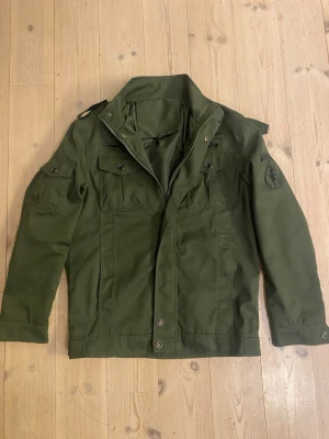 Grön Overshirt/fieldjacket - Säljer denna snygga Overshirt/fieldjacket från Bruno Archive, köpte den för 749kr men den passade, använd 2-3 ggr! Den är i strl L men sitter som M.