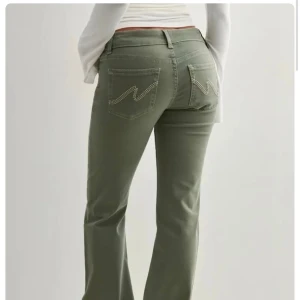 Gröna bootcut jeans från Nelly - Snygga gröna jeans från Nelly med bootcut passform och klassiska bakfickor med zigzag-söm. Jeansen har normal midja och är gjorda i ett mjukt denimtyg. 