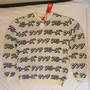 Långärmad tröja - Stickad tröja. Texten betyder santa cruz. Den är rätt stor för att vara medium