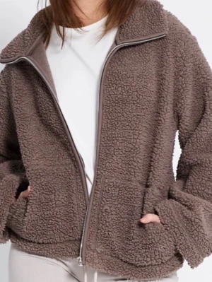 Brun teddyjacka med dragkedja - Mysig brun teddyjacka med dragkedja framtill och två stora fickor. Jackan har en avslappnad passform och hög krage. 