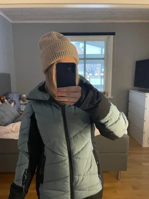 Ljusblå pufferjacka med svarta detaljer - Säljer en ljusblå slalom jacka med mycket bra fickor till liftkort och annat. Använd ganska lite och i bra skick 