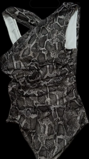 Ormmönstrad body  - Body med ormmönster från New Yorker. Storlek XS. Bodyn är aldrig använd, helt ny utan prislapp. Inga defekter. Perfekt för en utgång/festival. 🩶