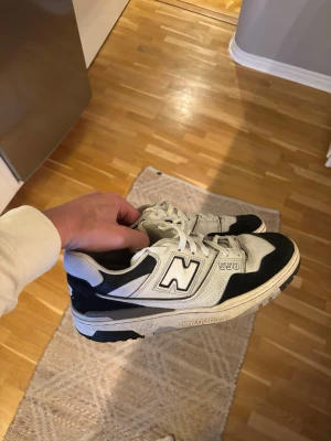 New Balance 550 White Black Rain Cloud - OBS! Sällsynta! Finns på nätet i denna storlek för cirka 3-4 tusen. Säljer ett par New Balance White Black Rain Cloud.  Skorna har klassisk låg siluett, tydlig N-logga på sidan och 550-detalj. Ovandelen är i läder och mesh för både stil och komfort. Perfekta för dig som gillar retrovibbar och streetwear. 