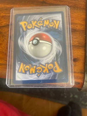 Lapras EX Pokémonkort - Säljer ett Lapras EX Pokémonkort med 210 HP. Kortet har en blå och silver design med Lapras i vattnet och tydliga attacker som Hydro Turn och Surf. Kortet ligger i ett genomskinligt plastfodral för extra skydd.