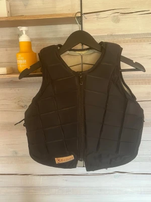 Svart säkerhetsväst från Racesafe - Säkerhetsväst från Racesafe, använd mycket. Slitagen på insidan är ej från min användning (köptes begagnad). I storlek xxl barn. 