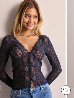 Mörkblå spetsblus med v-ringning - Snygg mörkblå blus i genombruten spets med v-ringad hals och långa ärmar. Använd några enstaka tillfällen och har inge defekter, skriv för fler bilder (obs bilderna är lånade från nellys hemsida) 💕