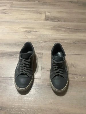 Gråa arigato skor - Stilrena grå skor från Axel arigato