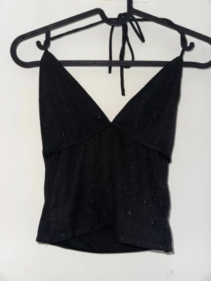 Glittrig haltertop - Supersöt glittrig svart haltertop med knyte i nacken. Passar perfekt till fest eller nyår🩷