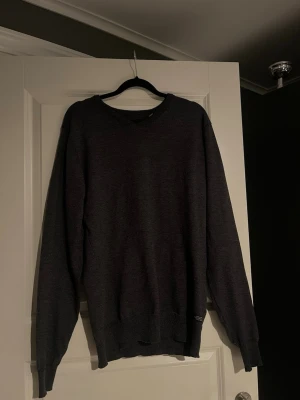 Blend Sweatshirt - En enkel och stilren mörkgrå tröja med rund halsringning och långa ärmar. Tröjan har ribbade muddar vid ärmslut och nederkant samt en liten diskret etikett nertill. Perfekt för lager på lager och passar till det mesta.