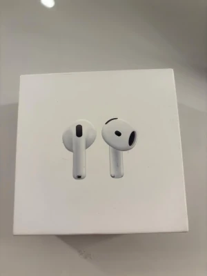 Apple AirPods 4 trådlösa hörlurar - Säljer ett par vita Apple AirPods 4 med laddningsetui. Hörlurarna har en stilren och kompakt design i plast, perfekt för dig som vill ha trådlös frihet och grymt ljud. Passar smidigt i fickan och kopplas enkelt till din iPhone eller andra Apple-enheter. Inte använda många gånger 