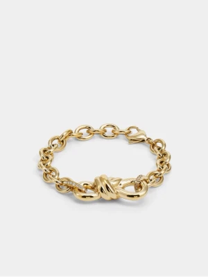 Guldfärgat armband med knutdetalj från GUESS - Snyggt armband i guldfärgad metall med chunky länkar och en stor knutdetalj i mitten. Armbandet har gnistrande stenar på vissa länkar och stängs med ett klassiskt klolås. 