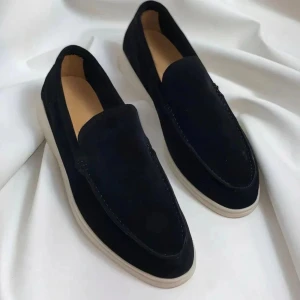 Svarta mockaloafers med vit sula - Stilrena svarta loafers i mocka med vit sula. Klassisk design med rundad tå och diskreta sömmar. Perfekta för dig som vill ha en enkel men snygg sko till vardagslooken. Hjälper min bror att sälja dessa. Helt nya och oanvända!