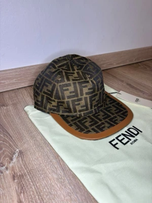 Äkta Fendi keps  - Säljer en helt ny Fendi keps.                                                                                              Har flera kepsar på profilen.                                          Kan tänka mig sänka priset vid snabb affär.             Vid flera frågor hör av dig.                                          Fick den i present dock inget kvitto medföljer.