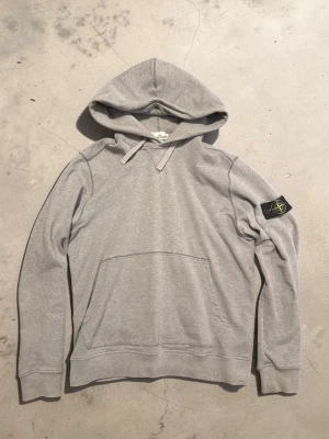 Stone island hoodie - Väldigt fin hoodie från Stone Island, i väldigt bra skick och även äkta! Storlek L, gråfärgad, inga defekter! Har ni fler frågor så skicka ett DM! Mvh