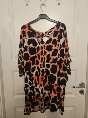 Djurmönstrad tunika storlek 50/52 - 1 st tunika med fjärilsärm i härligt mönster i mycket gott skick. Fjärilsärmen gör denna tunika svår att mäta över bysten. Midjemåttet är ca 135 cm och längden 82 cm. Den har lyster och stretch i tyget och är mjuk och behaglig att bära.