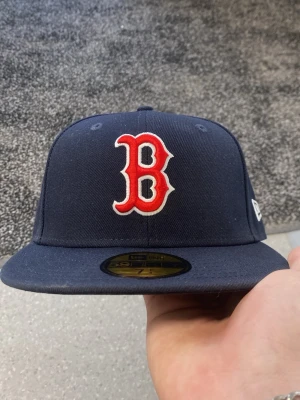 Mörkblå Boston Red Sox keps - Snygg mörkblå 59FIFTY keps från New Era med Boston Red Sox logga broderad i rött och vitt framtill. Klassisk rak skärm och officiell MLB On-Field modell. Tillverkad i ett slitstarkt material som håller formen.