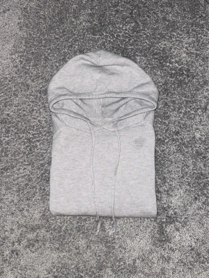 Ljusgrå kashmir hoodie - En stilren ljusgrå hoodie med klassisk huva och dragsko. Hoodien har en enkel design utan synliga loggor eller tryck, vilket gör den lätt att matcha med olika outfits. Tillverkad i mjukt material som känns skönt mot huden.