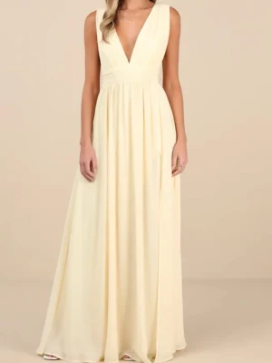Ljusgul långklänning med v-ringning - Elegant långklänning i ljusgul nyans med djup v-ringning både fram och bak. Klänningen har ärmlös design, markerad midja och ett luftigt, svepande fall. Perfekt för dig som vill ha en stilren och feminin look. Säljer då den var för stor jag har endast testat en gång men retur kostar 600kr så testar här istället!☺️