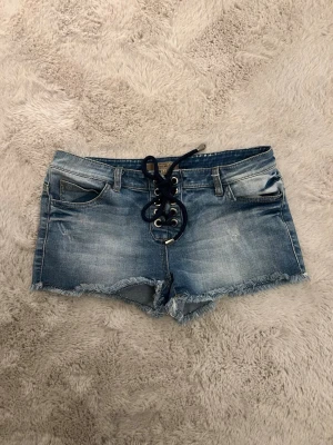 Supersnygga lågmidjade jeansshorts - Aldrig använt dem  Köpte de secondhand (den lilla fläcken på sista bilden va där då också) Står storlek 42, men är typ som en 36  Midjan rakt av är ca 37-38cm