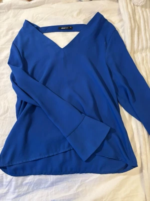 Blå blus från Gina Tricot - Blus från Gina Tricot med v-ringning i ett lätt tyg💗köpt på second hand, därav priset💞mycket bra skick trots lite användning, jag själv har använt denna kanske fyra fem ggr