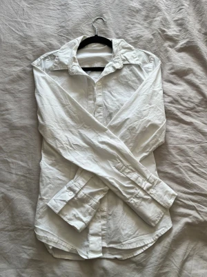 Vit klassisk skjorta i bomull - Klassisk vit skjorta med lång ärm och knappar framtill. 