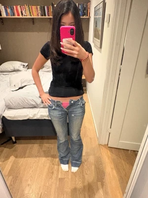 Blå bootcut low waist jeans - Säljer ett par blå bootcut jeans med låg midja och slitningar på låren. Säljer eftersom de tyvärr är för små, och därav aldrig använda. De har en vintage look och passar många olika stilar! Priset kan diskuteras. Midjemåttet rakt över är 37 cm, lår måttet mätte jag ungefär 20 cm ned från midjan där benen delar sig och måttet är 22 cm, och innerbenslängden är 81.5 cm 