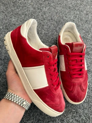 Valentino flycrew röd - Säljer nu dessa sjukt läckra och eftertraktade valentino flycrews! Perfekta sommarskorna! Size 41, innersula 27,5cm! Skick 8,5/10 inga skador bara allmänt använda! alla nitar kvar var av 4st är replacement. Box+ dustbag ingår! Skorna har slutat tillverkas vilket gör de extra sällsynta och håller värdet riktigt fint! Hör av dig vid minsta fundering !  Köp 🤩📦