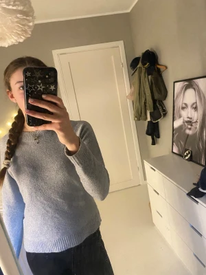 Grå stickad tröja från Vero Moda  - Mysig grå stickad tröja från Vero Moda med rund halsringning och ribbade muddar vid ärmslut och nederkant. Tröjan har en enkel och stilren design som passar perfekt till jeans eller kjol. Tröjan är väl använd, därav priset, annars bra skick!
