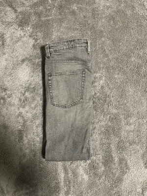 Gråa slim jeans  - Säljer ett par gråa slim jeans med raka ben och klassisk femficksdesign. Jeansen har normal passform och är tillverkade i slitstarkt denimtyg med snygg tvättad look. Perfekta till en avslappnad stil och funkar året runt.
