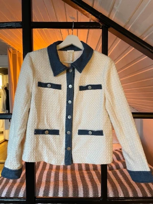  jacka/kofta med jeansdetaljer - Jacka/kofta med mörkblå jeansdetaljer på krage, knappslå, fickor och ärmslut. Jättesnygg till jeans! Köpt på plick✨Står inget märke eller storlek men skulle säga att den sitter som en S.