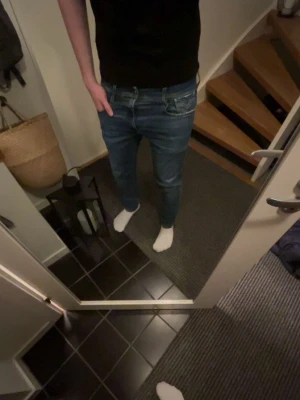 Replay Anbass ljusblå jeans - Snygga ljusblå Replay Anbass jeans med klassisk femficksdesign och diskreta slitningar. Jeansen har smal passform och är tillverkade i mjuk bomullsdenim med stretch för extra komfort. Perfekta för en avslappnad och trendig look.