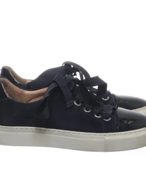 Mörkblå sneakers med lackdetaljer - Snygga mörkblå sneakers med breda matchande skosnören och coola lackdetaljer på tån. Skorna har vit sula och metallfärgade öljetter. Insidan är ljusbrun och materialet är en mix av mocka och lack. Perfekta för en trendig streetstyle-look.