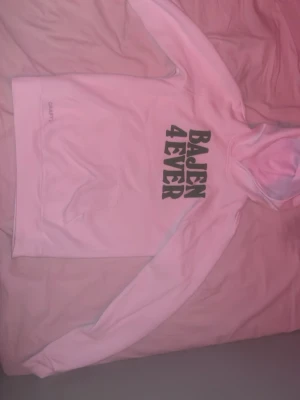 Vit hoodie Bajen 4EVER - Säljer en vit hoodie från Craft med trycket 'BAJEN 4EVER' i svart på bröstet. Hoodien har huva och långa ärmar, perfekt för dig som vill visa ditt stöd för Bajen. Mjuk och skön bomullsblandning.