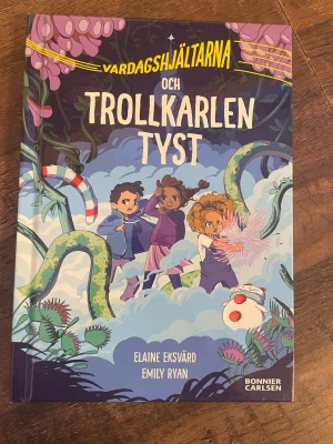 Vardagshjältarna och Trollkarlen Tyst - En färgglad och spännande barnbok med hårda pärmar, skriven av Elaine Eksvärd och illustrerad av Emily Ryan. Omslaget visar tre barn i en magisk skog med fantasifulla växter och en trollkarl. Perfekt för dig som gillar äventyr och magi.