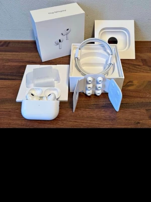 Apple AirPods Pro Gen 2 - Säljer ett par vita Apple AirPods Pro Gen 2 med laddningsetui, extra silikonpluggar och laddningskabel. Hörlurarna har en stilren och kompakt design i plast och levereras i originalförpackning. Perfekta för dig som vill ha brusreducering och grymt ljud. Hör av dig vid intresse 