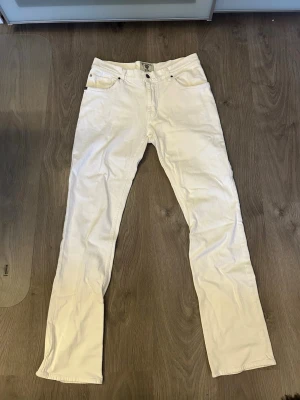 Vita jeans  - Säljer ett par vita jeans från Tiger of sweden, det står 34/34 men sitter mer som 32/33. Midjan är 40 cm, och längden 111 cm. 