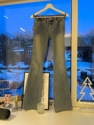 Ljusblå bootcut jeans True Religion - Säljer ett par ljusblå bootcut jeans från True Religion med klassiska kontrastsömmar och snygga fickdetaljer bak. Jeansen har låg midja och är tillverkade i denim med en lätt,snygg look. Perfekta för dig som gillar sköna low waist och vill ha ett par jeans som är bootcut. Storlek  24 men passar för liknande storlekar🤍