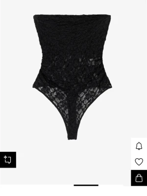 Svart spetsbody  - Säljer en svart genomskinlig spets med blommönster från Bershka. Endast testad en gång dock med båda lapparna bortklippta. Perfekt och snygg att ha till jeans eller kostymbyxor. Storlek S.