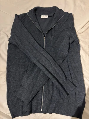 Ny Mörkblå ziptröja från Lindeberg M - Säljer denna mörkblåa/ grå stickade tröja med full zip från J Lindeberg slim fit och i storleken M. Aldrig använt den alltså helt ny, prislapp och kvitto finns kvar. Säljer den för att den var lite för stor för mig. Tveka inte på att höra av dig vid frågor! Priset är inte hugget i sten! 🪨 🔥